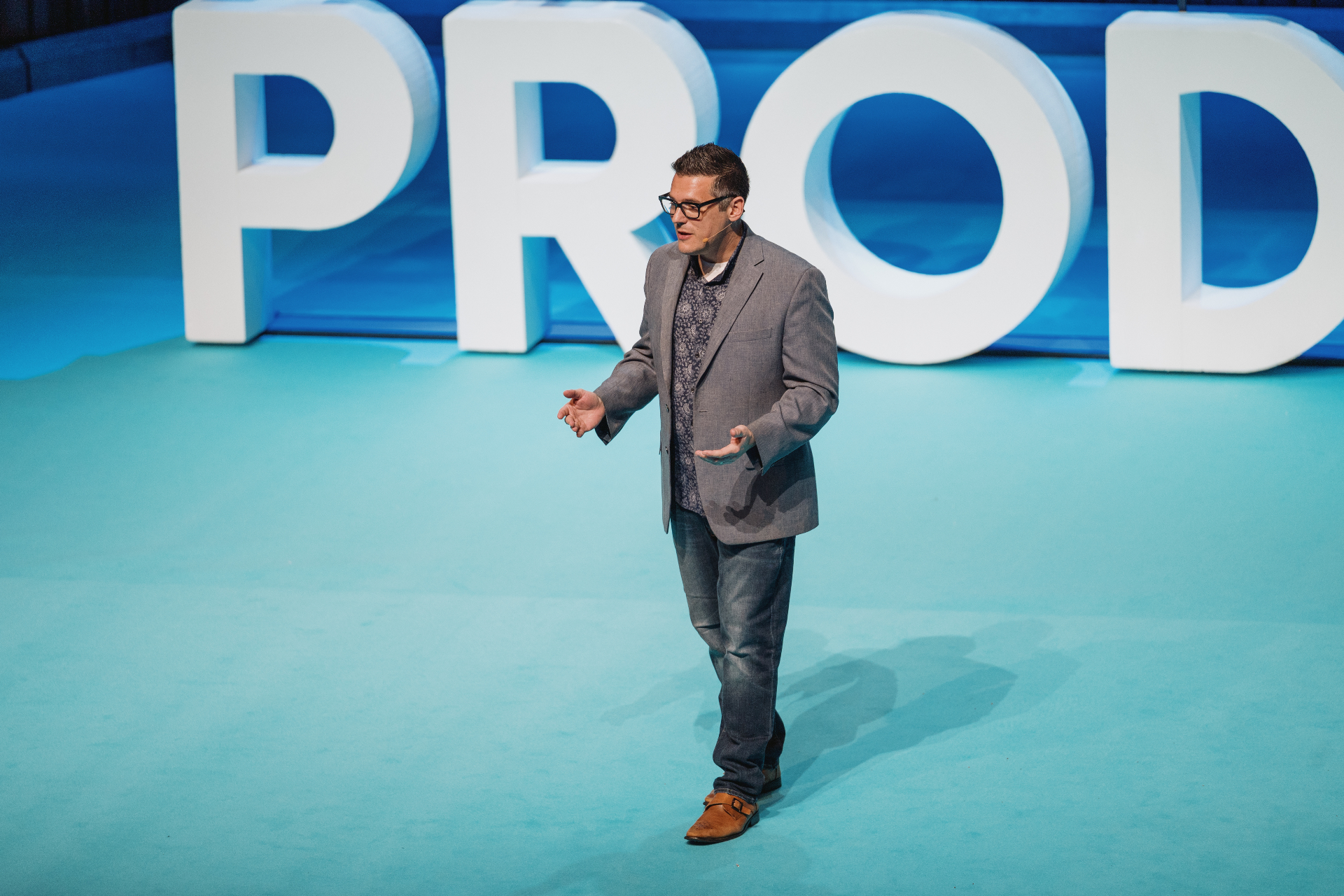 Mike Belsito speaking on stage at a product conference